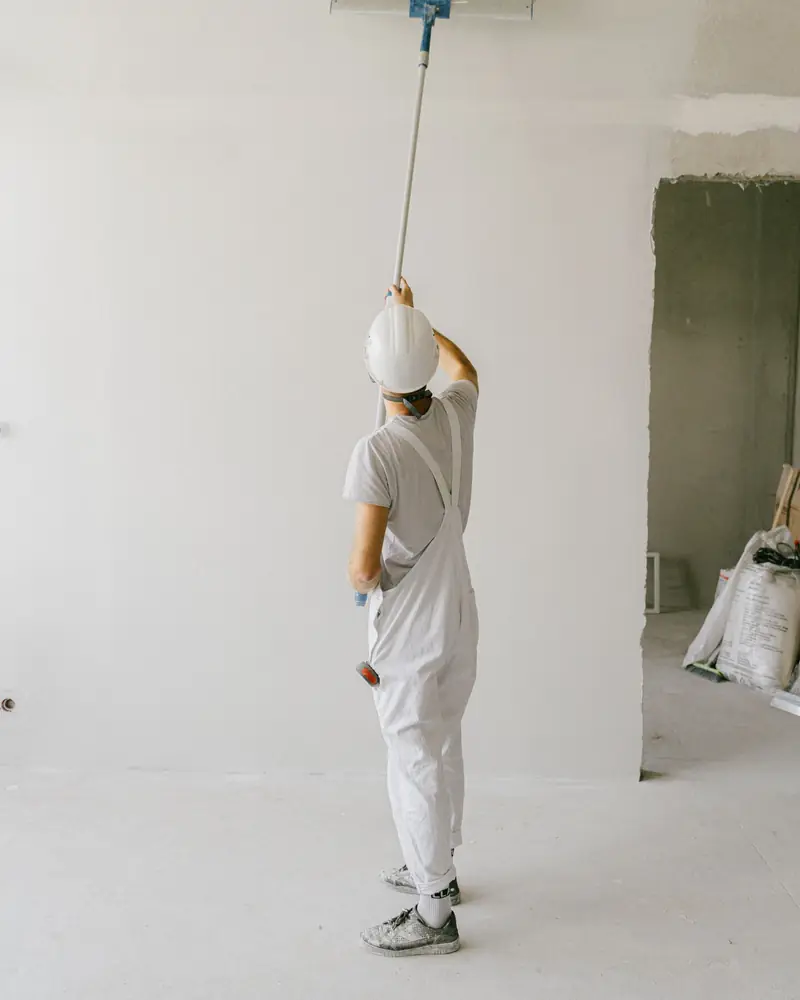 Painter rolling paint onto an interior wall